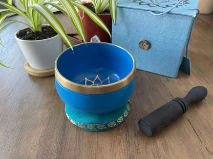Pictured is a small metal singing bowl with a pillow and a wood gong mallet. Blue Singing Bowl (Throat Chakra) 8cm