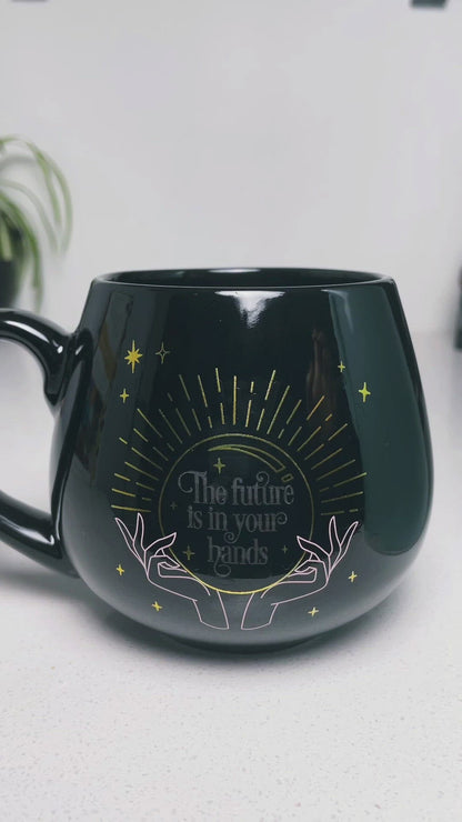 Pictured is a black ceramic mug with colour-changing words that say "The future is in your hands". Colour-changing Fortune Ceramic Mug video