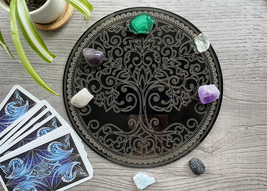 Pictured is a black acrylic crystal grid with a tree of life design. Tree of Life Crystal Grid